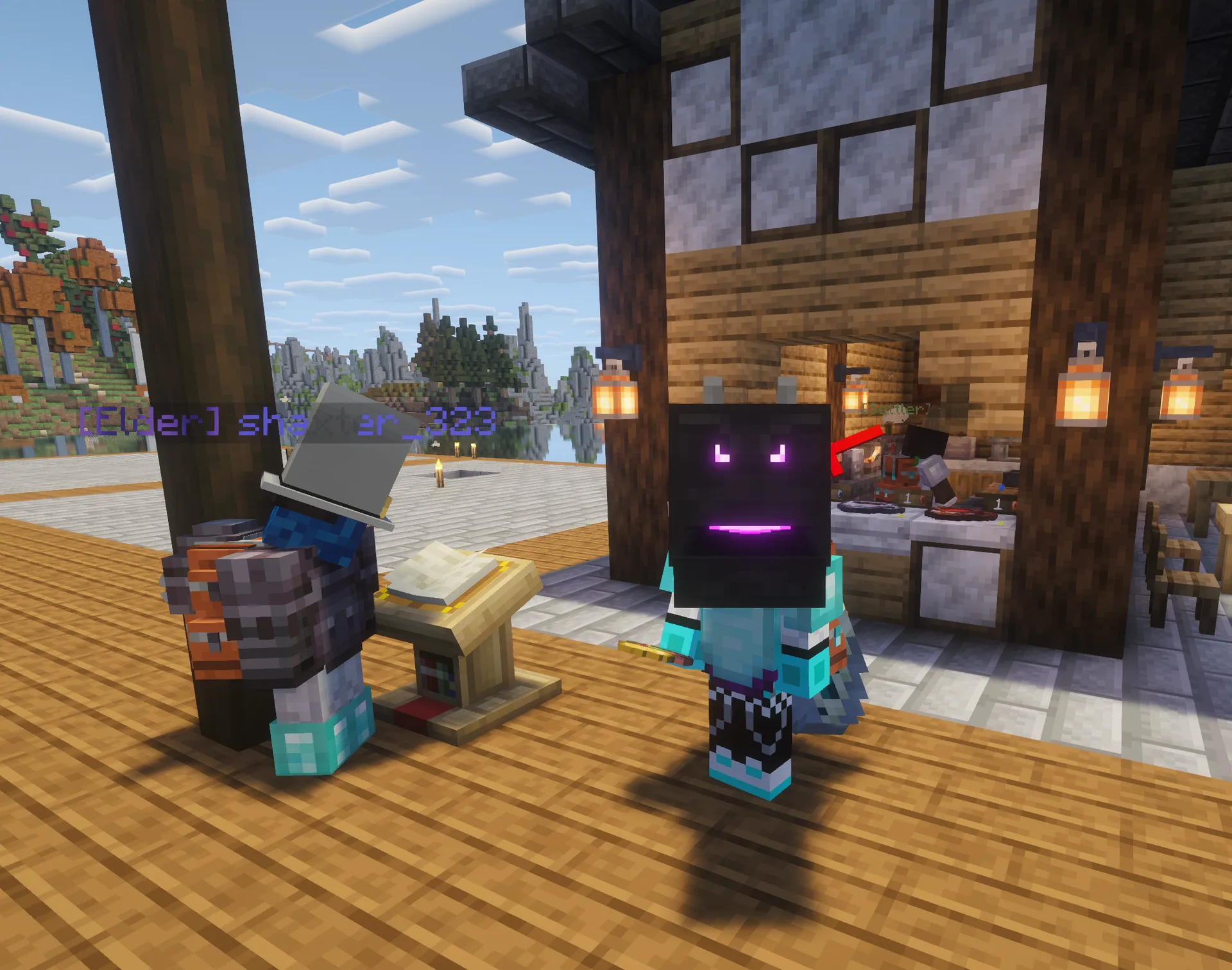 Daytime view of the boardwalk shop area: a player stands near a lectern and market stall as [Elder] shaxter_323 looks on, with misty peaks across the water behind.