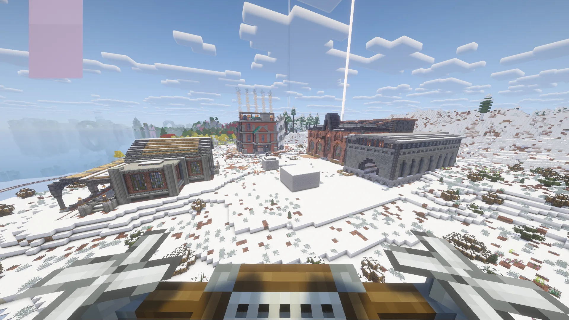 Aerial view of New Steamford: three brick-and-stone factory buildings and a station spread across a snowy valley.