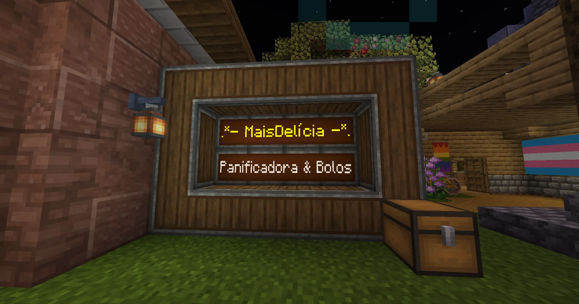 The illuminated MaisDelícia bakery sign set into a wood-framed storefront at night.