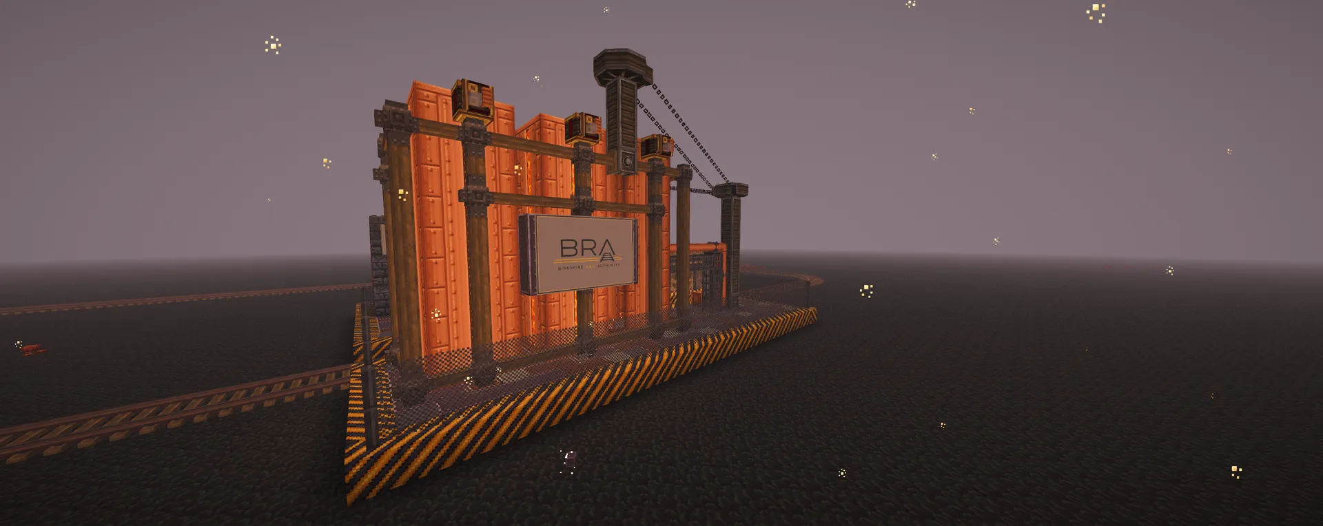 A dusk view of an industrial trackside structure with a 'BRA' sign, orange paneling, and an overhead crane beside the rail line under a lavender sky.