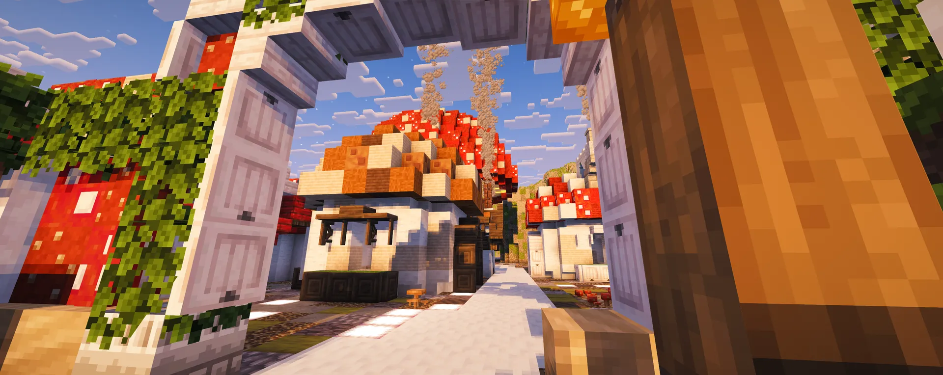 A sunlit lane of red mushroom-roofed houses framed by a white stone garden arch.