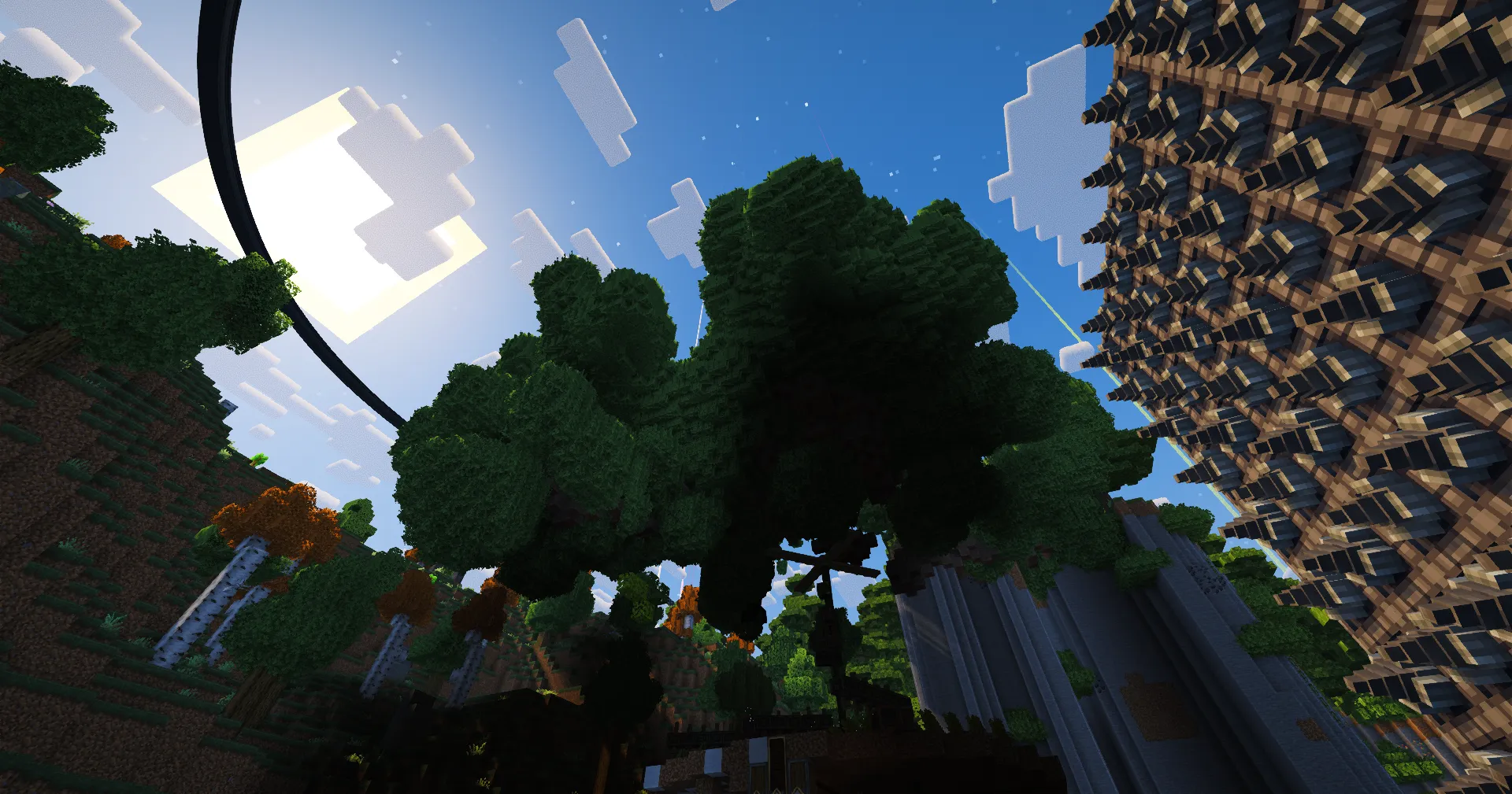 A massive newly grown tree towers beside a dense Create machine under a bright Homestead sky.