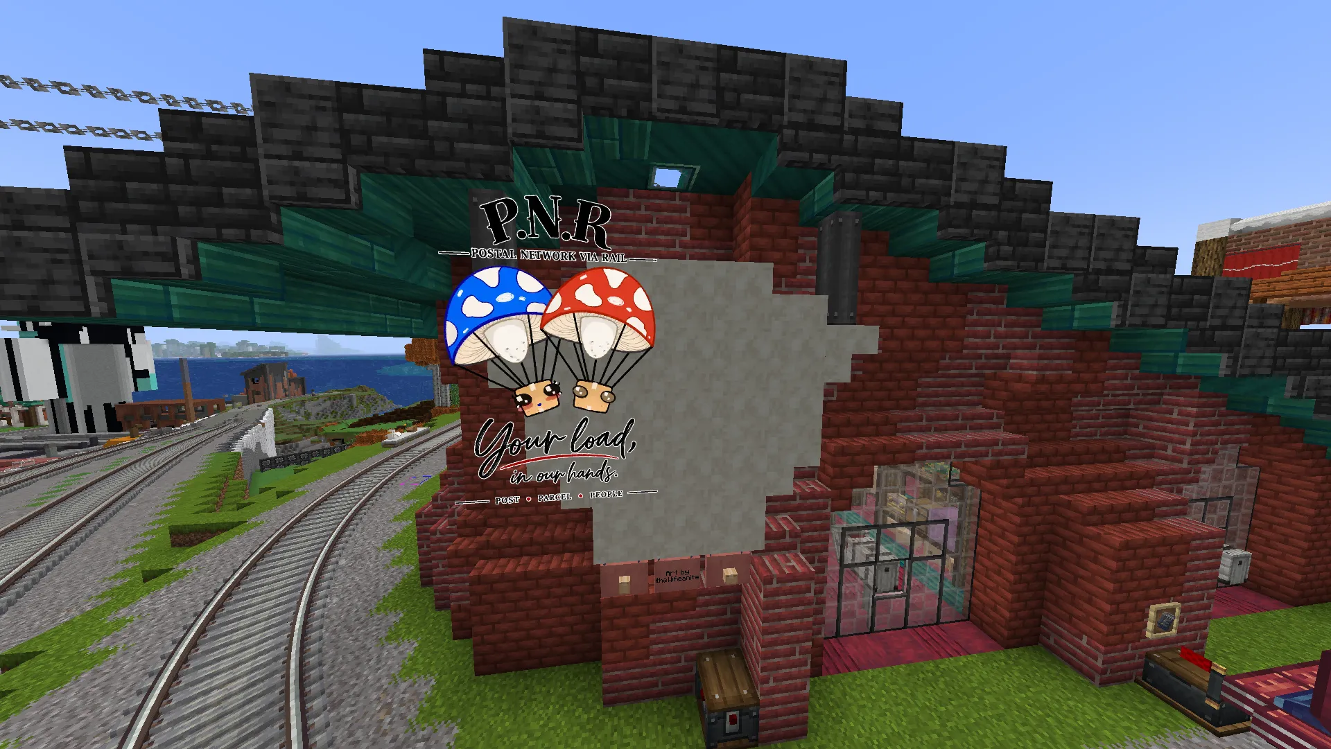 A red-brick P.N.R. rail depot beside curving tracks, with a large mushroom-parachute postal mural on its wall.