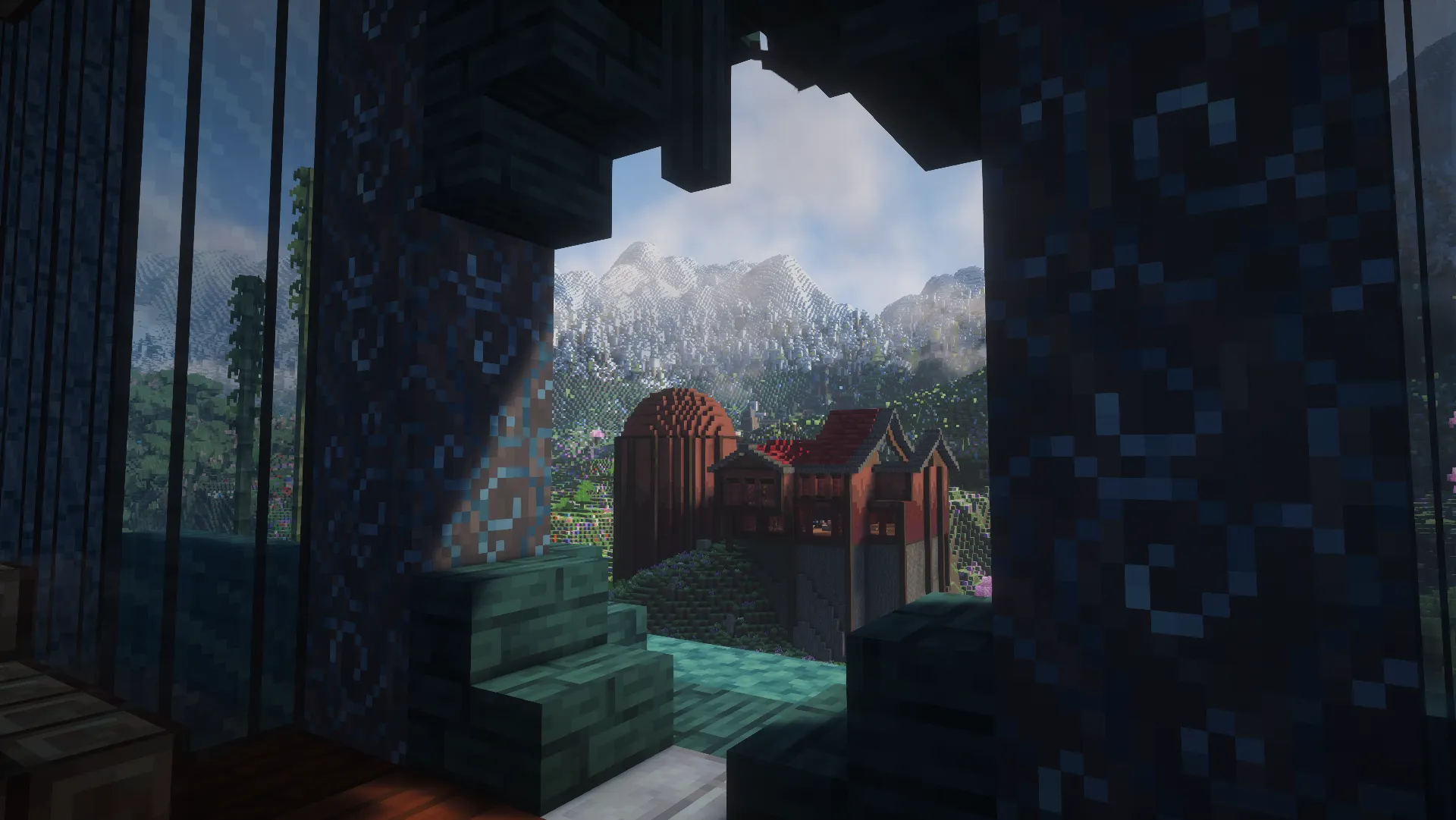 A red-roofed hillside build and snowy mountains seen through a blue-patterned arched opening.