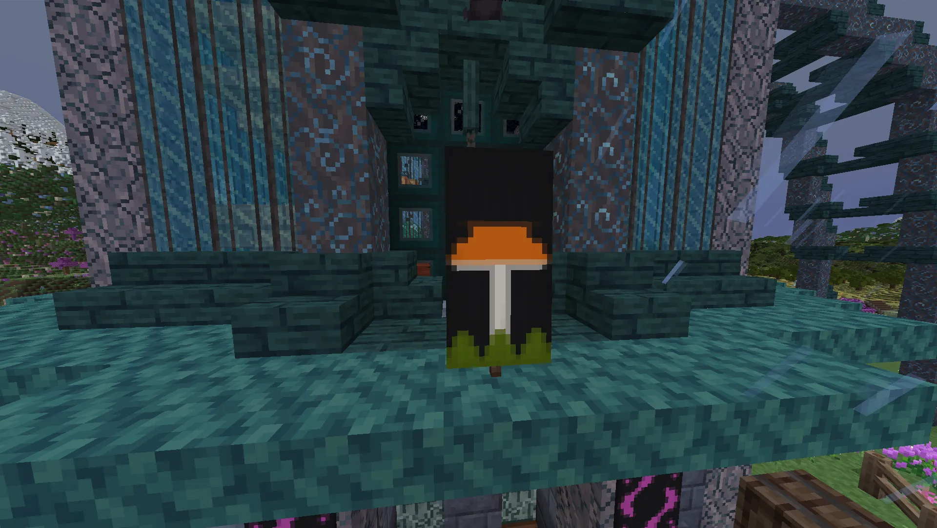 An orange mushroom banner stands on a teal ledge in front of a patterned blue-and-teal building.