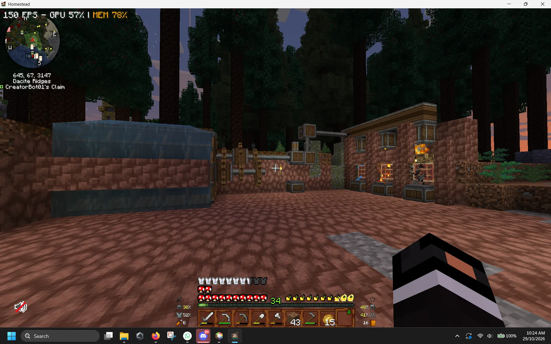 A Homestead workshop among tall trees, with a water tank, shafts and machinery beside a small brick building.